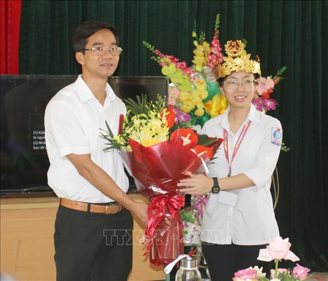 Trong ảnh: Thầy Vũ Đức Toàn - Hiệu trưởng Trường THPT Kim Sơn A tặng hoa chúc mừng em Nguyễn Thị Thu Hằng. Ảnh: Thùy Dung - TTXVN