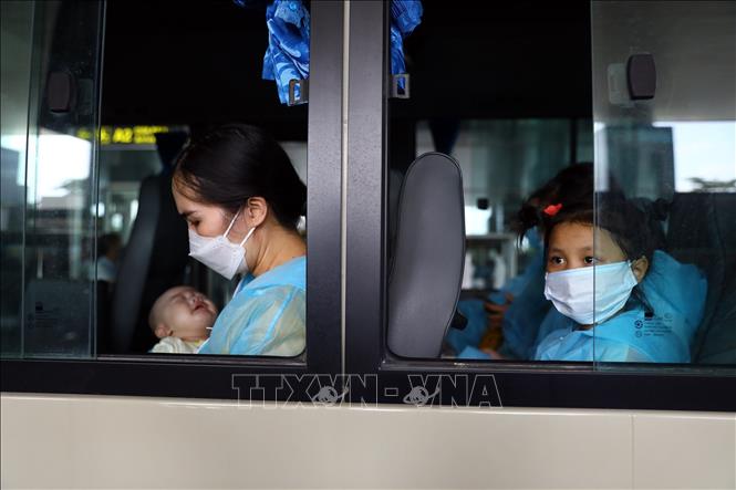 Trong ảnh: Chị Đào Thị Viên và con nhỏ mua được vé máy bay về nước sau 10 tháng kẹt tại Hàn Quốc. Chỉ trong 2 ngày, chị phải lo chi phí mua vé, làm xét nghiệm âm tính và liên hệ địa điểm cách ly tại Việt Nam. Ảnh: Huy Hùng - TTXVN