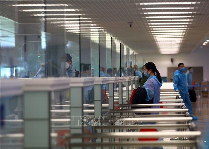 Trong ảnh: Hành khách làm thủ tục nhập cảnh trở về Việt Nam tại nhà ga T2 sân bay Nội Bài. Ảnh: Huy Hùng - TTXVN