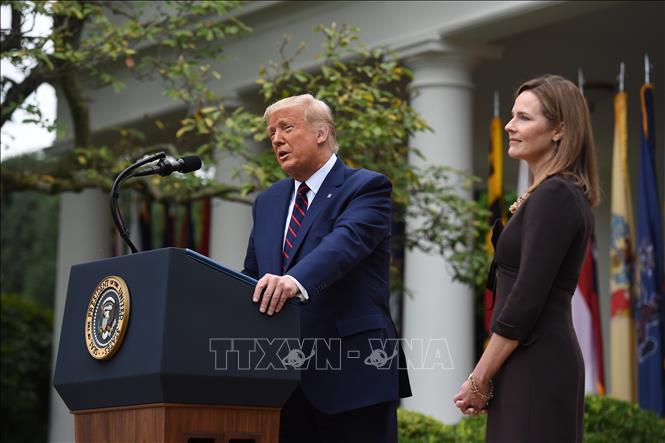 Trong ảnh: Tổng thống Mỹ Donald Trump (trái) phát biểu tại buổi lễ thông báo đề cử bà Amy Coney Barrett (phải) giữ cương vị Thẩm phán Tòa Tối cao, tại Washington DC., ngày 26/9/2020. Ảnh: AFP/TTXVN