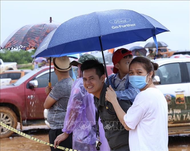 Trong ảnh: Một gia đình đội mưa đi theo dõi cuộc đua. Ảnh: Hoàng Hiếu - TTXVN