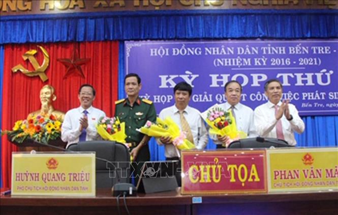 Trong ảnh: Bí thư Tỉnh ủy, Chủ tịch HĐND tỉnh Phan Văn Mãi và Chủ tịch UBND tỉnh Cao Văn Trọng trao hoa chúc mừng các đồng chí Ủy viên UBND tỉnh nhiệm kỳ 2016-2021. Ảnh: Công Trí- TTXVN