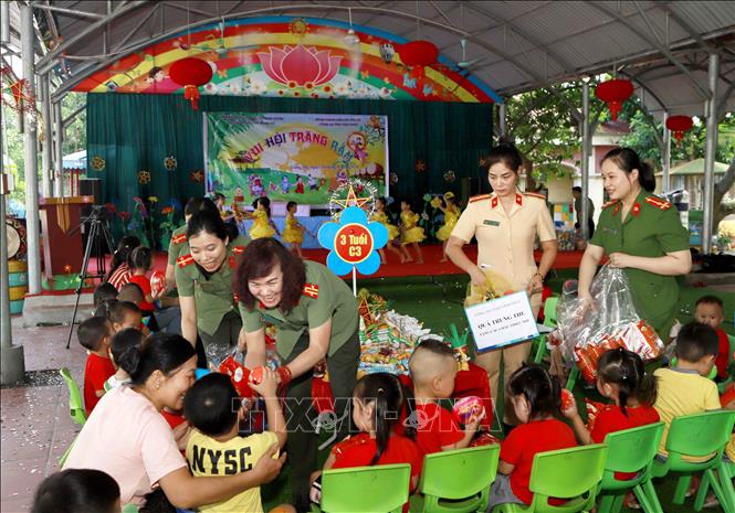 Trong ảnh: Đoàn công an tỉnh Vĩnh Phúc tặng quà cho học sinh trường mầm non xã Trung Mỹ. Ảnh: Hoàng Hùng - TTXVN