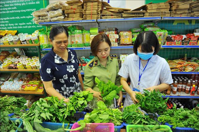 Đoàn kiểm tra ATVSTP kiểm tra thực phẩm và giấy tờ của các cửa hàng thực phẩm trên địa bàn thành phố Ninh Bình. Ảnh: Minh Đức - TTXVN