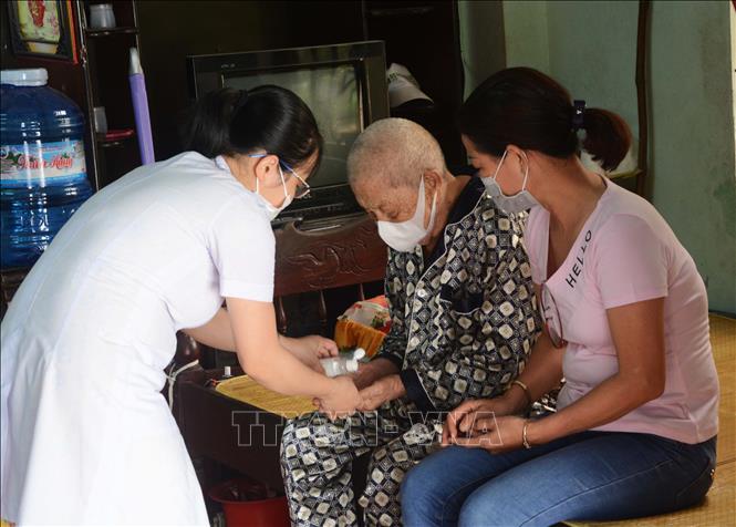 Để kiểm soát dịch bệnh COVID-19, giúp hạn chế người cao tuổi ra ngoài, Trung tâm Y tế Ngũ Hành Sơn (Đà Nẵng) đã huy động lực lượng, phối hợp với các Trạm y tế ở các phường, xuống tận nhà những người già có bệnh để thăm khám, phát thuốc và tuyên truyền về cách phòng chống dịch bệnh. Trong ảnh: Các bác sĩ đến tận nhà khám bệnh cho người già tại Đà Nẵng. Ảnh: Văn Dũng - TTXVN