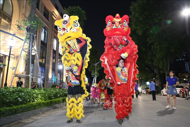 Trong ảnh: Đội lân sư rồng dẫn đầu đoàn rước tại phố Lê Đại Hành. Ảnh: Hoàng Hiếu - TTXVN