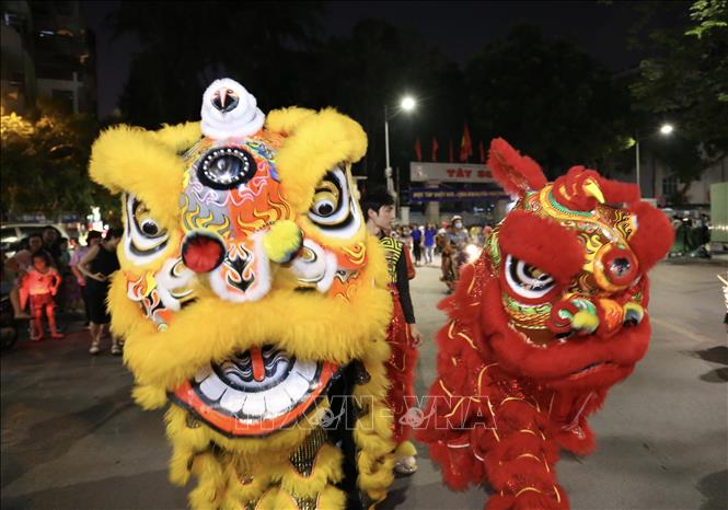 Trong ảnh: Đội lân sư rồng dẫn đầu đoàn rước tại phố Lê Đại Hành. Ảnh: Hoàng Hiếu - TTXVN