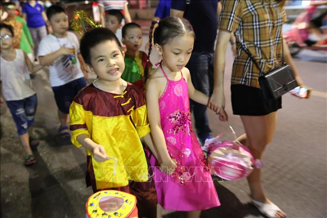 Trong ảnh: Các em nhỏ tham gia đoàn rước tại phố Lê Đại Hành. Ảnh: Hoàng Hiếu - TTXVN