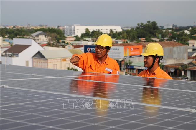 Trong ảnh: Công nhân Công ty Điện lực Thị xã Hòa Thành (Tây Ninh) kiểm tra hệ thống điện năng lượng mặt trời áp mái của người dân. Ảnh: Thanh Tân - TTXVN