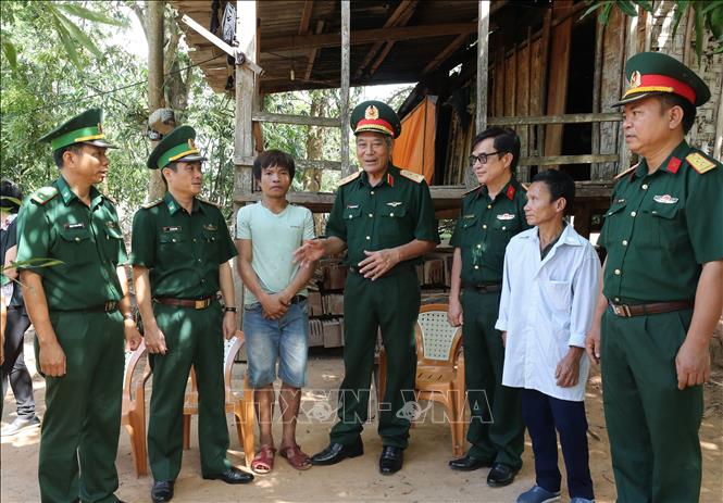 Đoàn công tác đến thăm và hỗ trợ bò sinh sản cho gia đình nạn nhân Hồ Nam, thuộc diện hộ nghèo bản Y leng, xã Dân Hoá, huyện Minh Hoá. Ảnh: Lâm Khánh - TTXVN