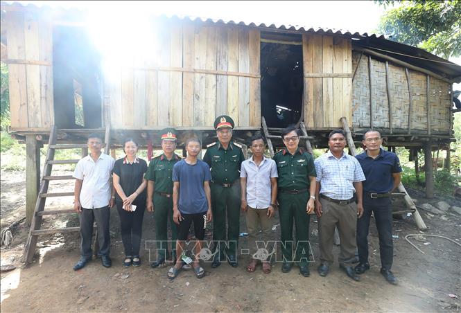 Đoàn công tác đến thăm và hỗ trợ bò sinh sản cho gia đình nạn nhân Hồ Bun, thuộc diện hộ nghèo bản La Trọng 2, xã Trọng Hoá, huyện Minh Hoá. Ảnh: Lâm Khánh - TTXVN