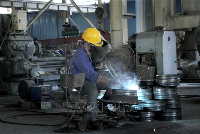 Công nhân Công ty TNHH Bê tông Phan Vũ Quảng Bình (Khu công nghiệp cảng biển Hòn La, Quảng Trạch, Quảng Bình) hoàn thiện các sản phẩm. Ảnh: Văn Tý-TTXVN