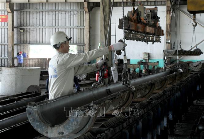 Công nhân Công ty TNHH Bê tông Phan Vũ Quảng Bình (Khu công nghiệp cảng biển Hòn La, Quảng Trạch, Quảng Bình) hoàn thiện các sản phẩm. Ảnh: Văn Tý-TTXVN