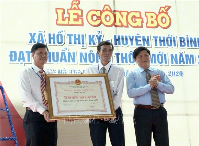Trong ảnh: Phó chủ tịch UBND tỉnh Cà Mau Lê Văn Sử trao Bằng công nhận xã đạt chuẩn nông thôn mới cho lãnh đạo xã Hồ Thị Kỷ. Ảnh: Huỳnh Anh - TTXVN