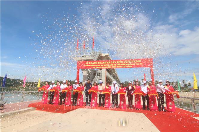 Trong ảnh: Các đại biểu cắt băng khánh thành đập ngăn mặn trên sông Lại Giang. Ảnh: Phạm Kha – TTXVN.