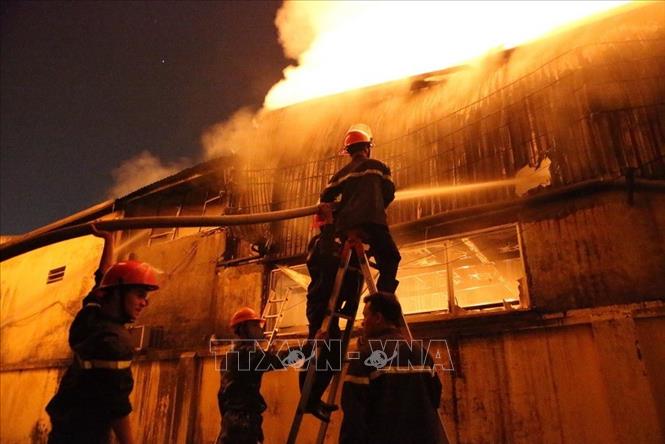 Trong ảnh: Cảnh sát PCCC tiếp cận sát hiện trường nỗ lực phun nước dập lửa trong  vụ cháy lớn xảy ra tại 6 nhà xưởng với diện tích trên 1.000m2 trong Khu công nghiệp La Phù, huyện Hoài Đức, Hà Nội. Ảnh: Doãn Tấn - TTXVN