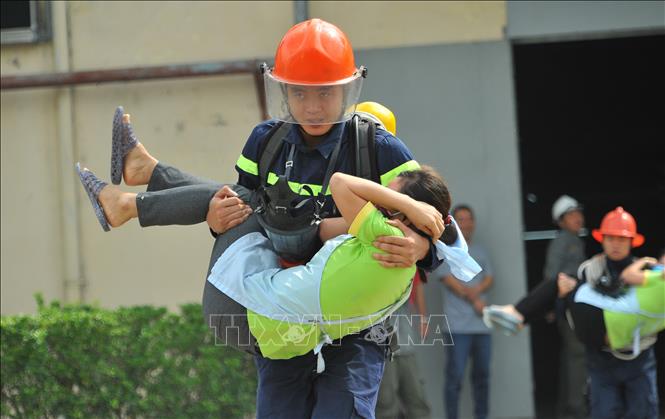 Trong ảnh: Diễn tập tình huống giả định khi công ty bị sự cố chập điện và xảy ra cháy do Phòng cảnh sát phòng cháy chữa cháy và cứu nạn - cứu hộ (Công an tỉnh Ninh Bình) phối hợp với Công ty TNHH may Nien Hsing tại khu công nghiệp Khánh Phú tổ chức. Ảnh: Minh Đức - TTXVN