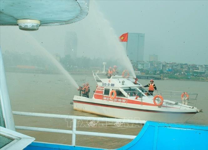 Trong ảnh: Sử dụng vòi rồng dập đám cháy bởi chất nổ trên chiếc tàu bị bọn khủng bố cướp trong Lễ diễn tập “Đánh bắt khủng bố, giải cứu con tin, rà phá bom mìn, cứu hộ, cứu nạn trên phương tiện giao thông đường thuỷ nội địa”. Ảnh: Thống Nhất-TTXVN