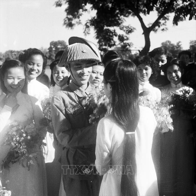 Trong ảnh: Thiếu tướng Vương Thừa Vũ, Tư lệnh Đại đoàn 308, Chủ tịch Ủy ban Quân chính Thành phố giữa vòng vây của các nữ sinh trường Trưng Vương tặng hoa chúc mừng bên hồ Hoàn Kiếm trong ngày giải phóng Thủ đô. Ảnh: Tư liệu TTXVN