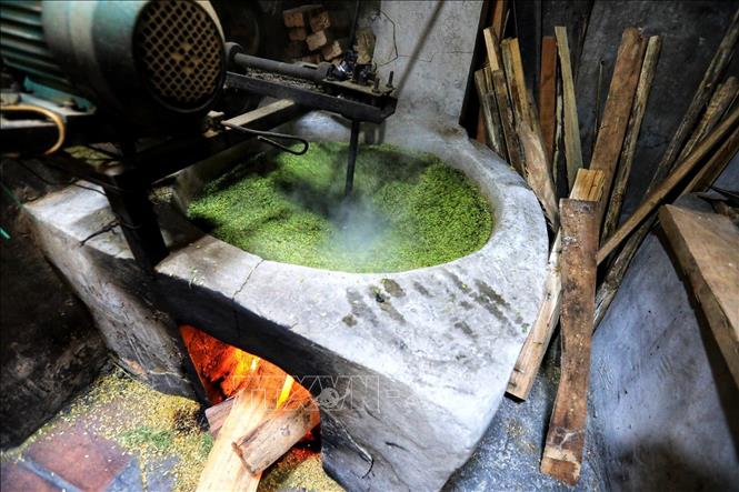 Photo: Grains are carefully sifted, washed and dried in a large pan over a soft fire. VNA Photo: Thành Đạt