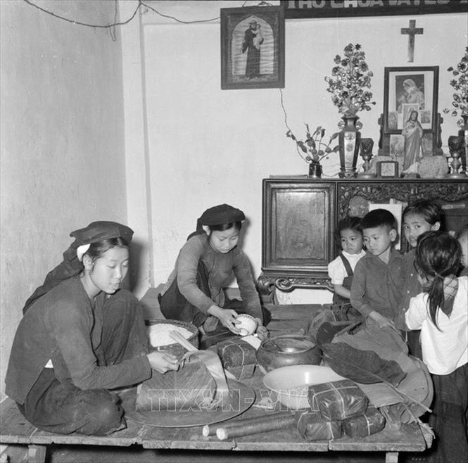 Trong ảnh: Một gia đình lao động Công giáo ngoại thành Hà Nội gói bánh chưng Tết Bính Thân 1956. Ảnh: TTXVN  