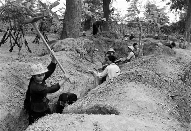 Năm 1972, khi Mỹ tiến hành cuộc chiến tranh phá hoại miền Bắc lần thứ 2, quân và dân Hà Nội không nao núng. Các trận địa của dân quân, tự vệ bắn máy bay tầm cao, tầm thấp và tổ chức phục vụ bộ đội chiến đấu, đánh trả giặc Mỹ rất quyết liệt. Trong ảnh: Dân quân xã Phú Diễn, huyện Từ Liêm (ngoại thành Hà Nội) đào hào giao thông, sẵn sàng chiến đấu chống máy bay Mỹ bắn phá (năm 1972). Ảnh: Xuân Vi - TTXVN