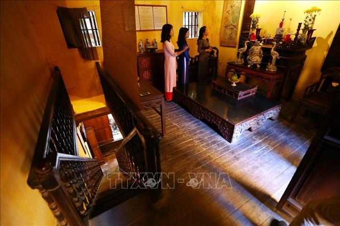 Photo: The altar of ancestors is placed in a sacred place in the living room on the first floor with two wooden plaques with Chinese verses, a popular thing in the past. VNA Photo