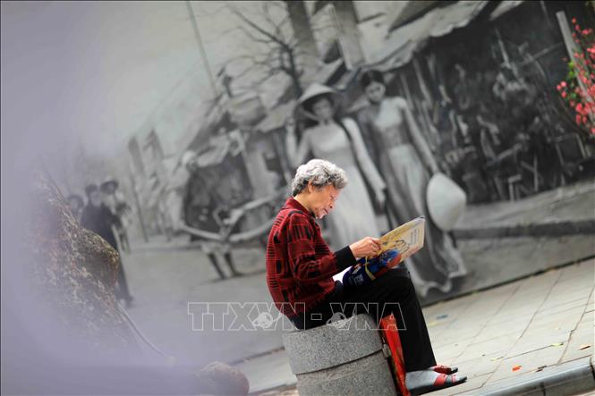 Trong ảnh: Thói quen đọc báo sớm của người Hà Nội. Ảnh: Nhật Anh - TTXVN