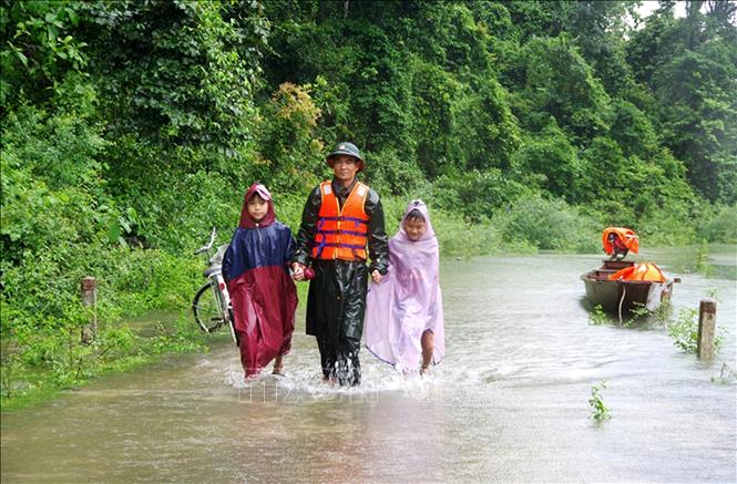 Trong ảnh: Lực lượng bộ đội Đồn biên phòng Cà Xèng, Bộ đội biên phòng tỉnh Quảng Bình giúp đở các em học sinh đi lại trong mưa lũ. Ảnh: Văn Tý-TTXVN