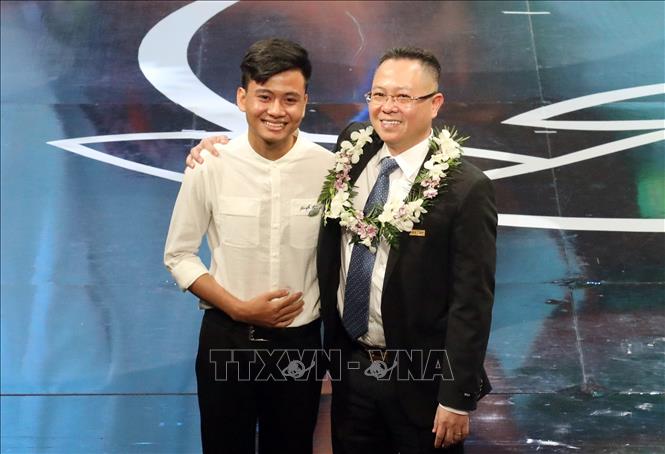 Trong ảnh: Cặp lá yêu thương em Bùi Công Dân và ông Lê Hải, Tổng Giám đốc Ngân hàng Thương mại cổ phần An Bình tại chương trình. Ảnh: Anh Tuấn – TTXVN