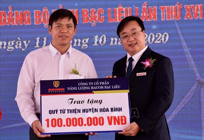 Trong ảnh: Ông Vũ Việt Long-Phó Tổng giám đốc Công ty Cổ phần Đầu tư Hacom Holdings (bên phải) tặng tặng 100 triệu đồng cho Quỹ từ thiện huyện Hòa Bình, tỉnh Bạc Liêu. Ảnh: Nhật Bình - TTXVN