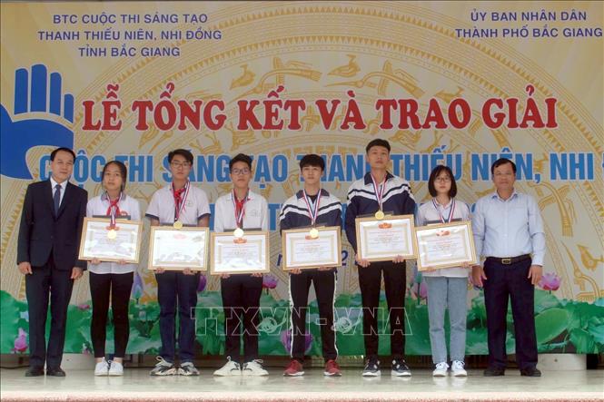 Phó Chủ tịch UBND tỉnh Bắc Giang Phan Thế Tuấn (bên phải) trao giải cho các tác giả có mô hình, sản phẩm đoạt giải. Ảnh: Đồng Thúy-TTXVN