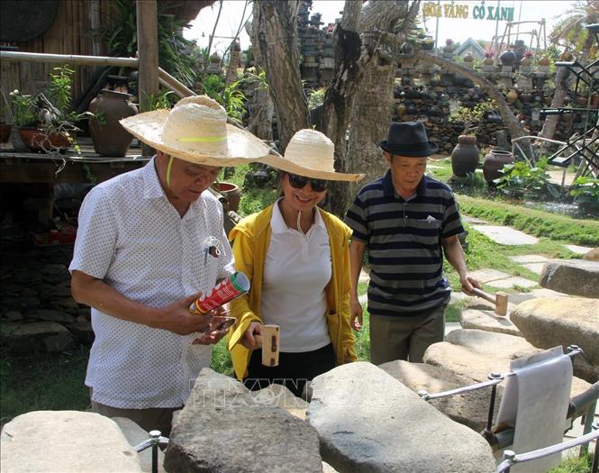 Trong ảnh: Du khách trải nghiệm sản phẩm du lịch văn hóa đá. Ảnh: Xuân Triệu - TTXVN