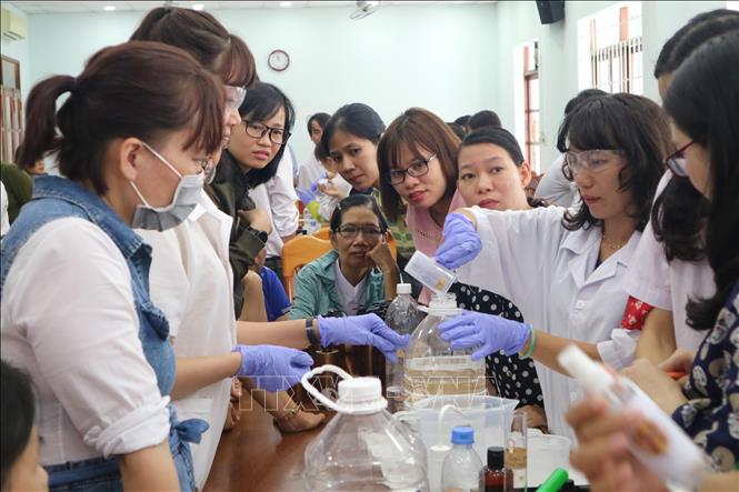 Trong ảnh: Nhóm giáo viên có chuyên môn về hóa sinh lấy tên “Seeds of Hope” tập huấn thực hành pha chế dung dịch sát khuẩn cho các các giáo viên của tỉnh Khánh Hòa để phòng, chống dịch COVID 19. Ảnh: Phan Sáu - TTXVN