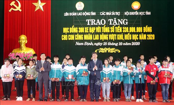 Trong ảnh: Trao học bổng bằng xe đạp cho con công nhân lao động vượt khó, học giỏi tỉnh Nam Định. Ảnh: Nguyễn Lành - TTXVN


