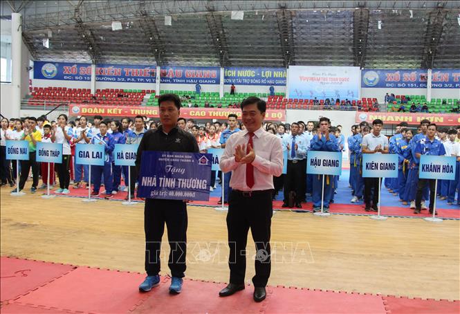 Trong ảnh: Đại diện võ sinh có hoàn cảnh khó khăn nhận bảng tượng trưng Nhà đại đoàn kết. Ảnh: Hồng Thái - TTXVN