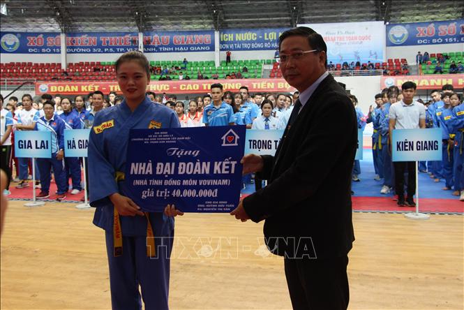 Trong ảnh: Đại diện võ sinh có hoàn cảnh khó khăn nhận bảng tượng trưng Nhà đại đoàn kết. Ảnh: Hồng Thái - TTXVN