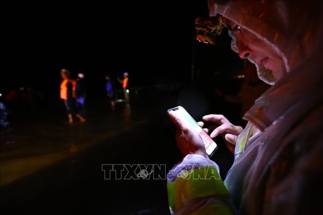 Trong ảnh: Lực lượng chức năng tranh thủ cập nhật tình hình mưa lũ tại Hà Tĩnh. Ảnh: Minh Quyết - TTXVN