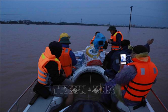 Trong ảnh: Dù trời bắt đầu tối, các đội công tác vẫn tiến vào vũng lũ xã Cẩm Vinh, huyện Cẩm Xuyên để cứu hộ, cứu trợ người dân bị cô lập. Ảnh: Vũ Sinh - TTXVN