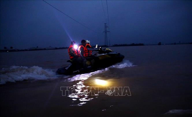Trong ảnh: Lực lượng chức năng tỉnh Hà Tĩnh dùng ca nô di chuyển trong đêm vào cứu trợ người dân bị cô lập thuộc 6 thôn của xã Cẩm Vĩnh, huyện Cẩm Xuyên, tỉnh Hà Tĩnh (ảnh chụp 19 giờ ngày 20/10/2020). Ảnh: Thành Đạt - TTXVN