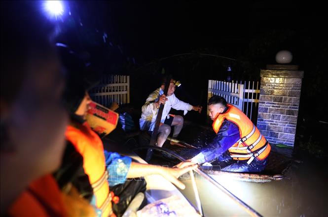 Trong ảnh: Lực lượng chức năng tỉnh Hà Tĩnh dùng ca nô di chuyển trong đêm vào cứu hộ gia đình ông Phan Đức Thanh đang bị cô lập ở xã Cẩm Vĩnh, huyện Cẩm Xuyên, tỉnh Hà Tĩnh (ảnh chụp 19 giờ ngày 20/10/2020). Ảnh: Thành Đạt - TTXVN