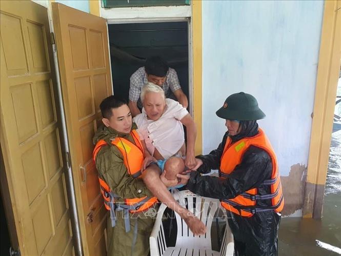 Trong ảnh: Người già, trẻ em vùng ngập lụt ở Hà Tĩnh được đưa đến những địa điểm an toàn. Ảnh: TXVN