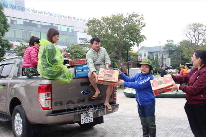 Các đội nhóm cứu trợ vận chuyển hàng từ trung tâm thành phố để đến các vùng bị ngập sâu. Ảnh: Hoàng Ngà - TTXVN