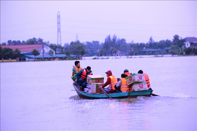 Vận chuyển hàng cứu trợ bằng xuồng máy vào các vùng ngập sâu. Ảnh: Hoàng Ngà - TTXVN