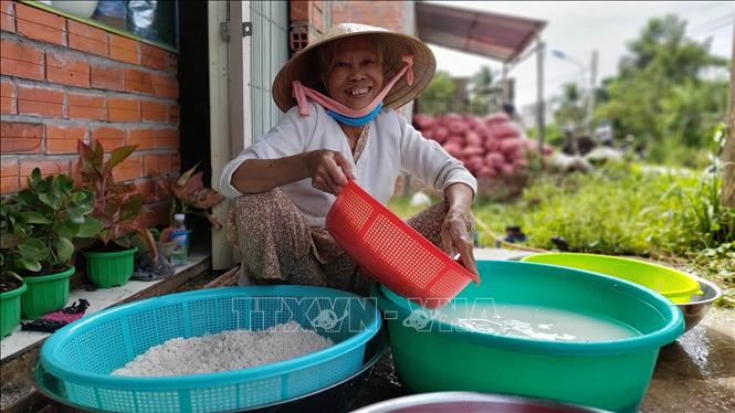 Bà Lư Thị Nguyệt, 72 tuổi, thị trấn Chợ Lách tham gia gói bánh tét ủng hộ đồng bào miền Trung. Ảnh: Trần Thị Thu Hiền - TTXVN
