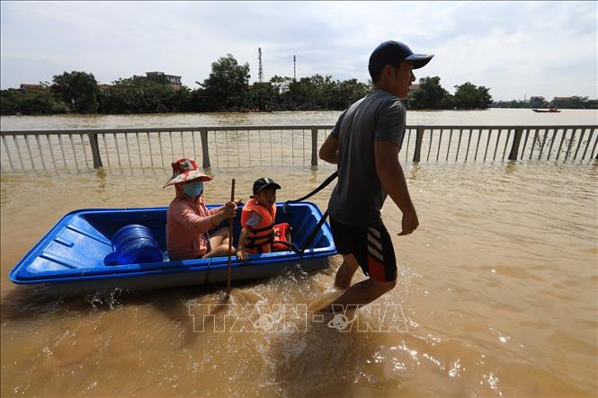 Trong ảnh: Người dân Lệ Thủy sử dụng đủ mọi cách để di chuyển trong nước lũ. Ảnh: Thành Đạt - TTXVN
