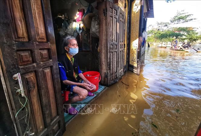 Trong ảnh: Nước ngập sâu thế này khiến người dân chỉ còn cách mong ngóng hàng cứu trợ. Ảnh: Thành Đạt - TTXVN