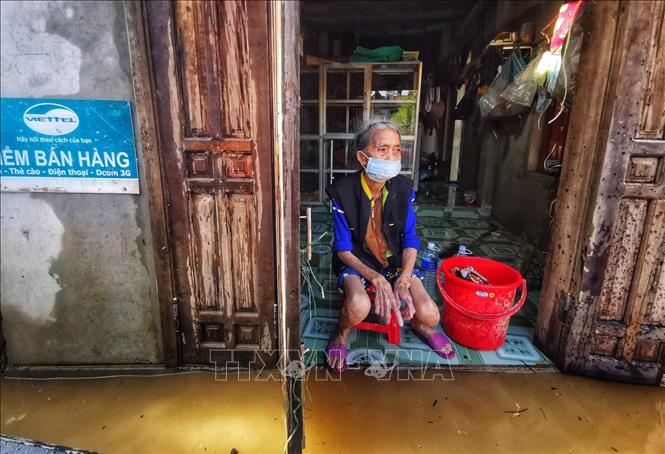 Trong ảnh: Một cụ già ngồi mong ngóng hàng cứu trợ. Ảnh: Thành Đạt - TTXVN