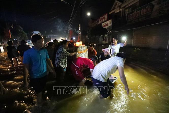 Trong ảnh: Hình ảnh éo le khi đám tang phải di chuyển trong đêm, xung quanh là nước lũ. Ảnh: Thành Đạt - TTXVN