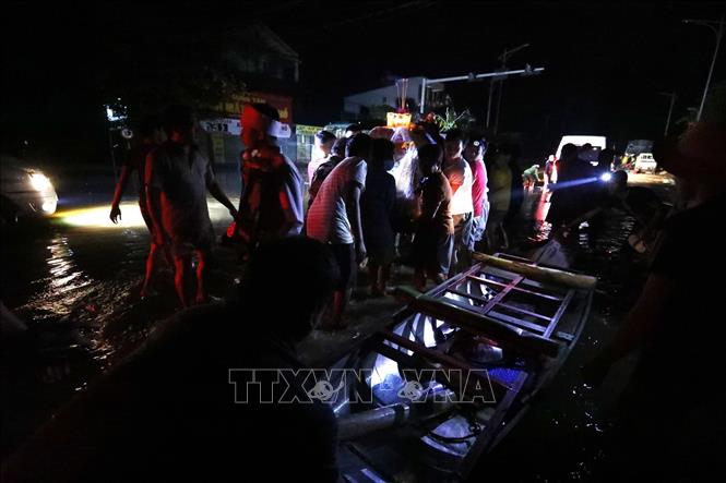Trong ảnh: Di chuyển linh cữu lên bè và chuyển tiếp lên khu vực khô ráo hơn. Ảnh: Thành Đạt - TTXVN